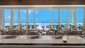 A restaurant with a view of the ocean, large windows, and ceiling fans. - West Bay Club first floor Coach Home with Lake View (Estero)