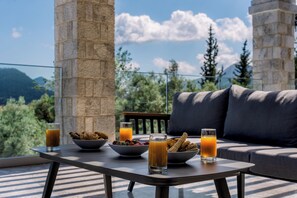A table with breakfast items and drinks on a balcony with a mountain view. - BRAND NEW LUXURY 4-BEDROOM VILLA IN CENTRAL LOCATION -70 METERS FROM THE SEA! (Nydri)