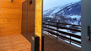 Un interior moderno con paneles de madera y ventanas amplias que muestran una vista nevada de las montañas.