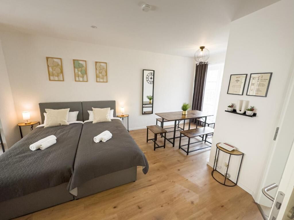 A bedroom with a large bed, bedside tables, a desk, and a chair.