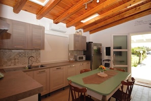 A kitchen with wooden cabinets, a microwave, and a refrigerator.