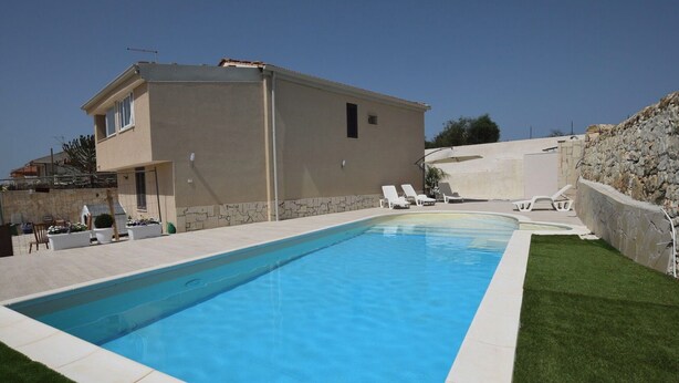 A swimming pool with a house in the background. - Stunning  villa for 4 guests with A/C, WIFI, private pool, TV, patio and panoramic view (Marina Di Ragusa)