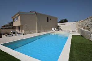A swimming pool with a house in the background. - Wonderful  villa for 4 people with A/C, private pool, WIFI, TV, patio and panoramic view (Marina Di Ragusa)