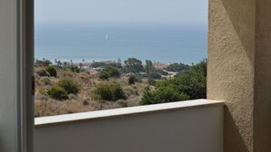A view through a window of a coastal area with houses, trees, and the sea. - Wonderful  villa with A/C, private pool, WIFI, TV, patio, pets allowed and panoramic view (Marina Di Ragusa)