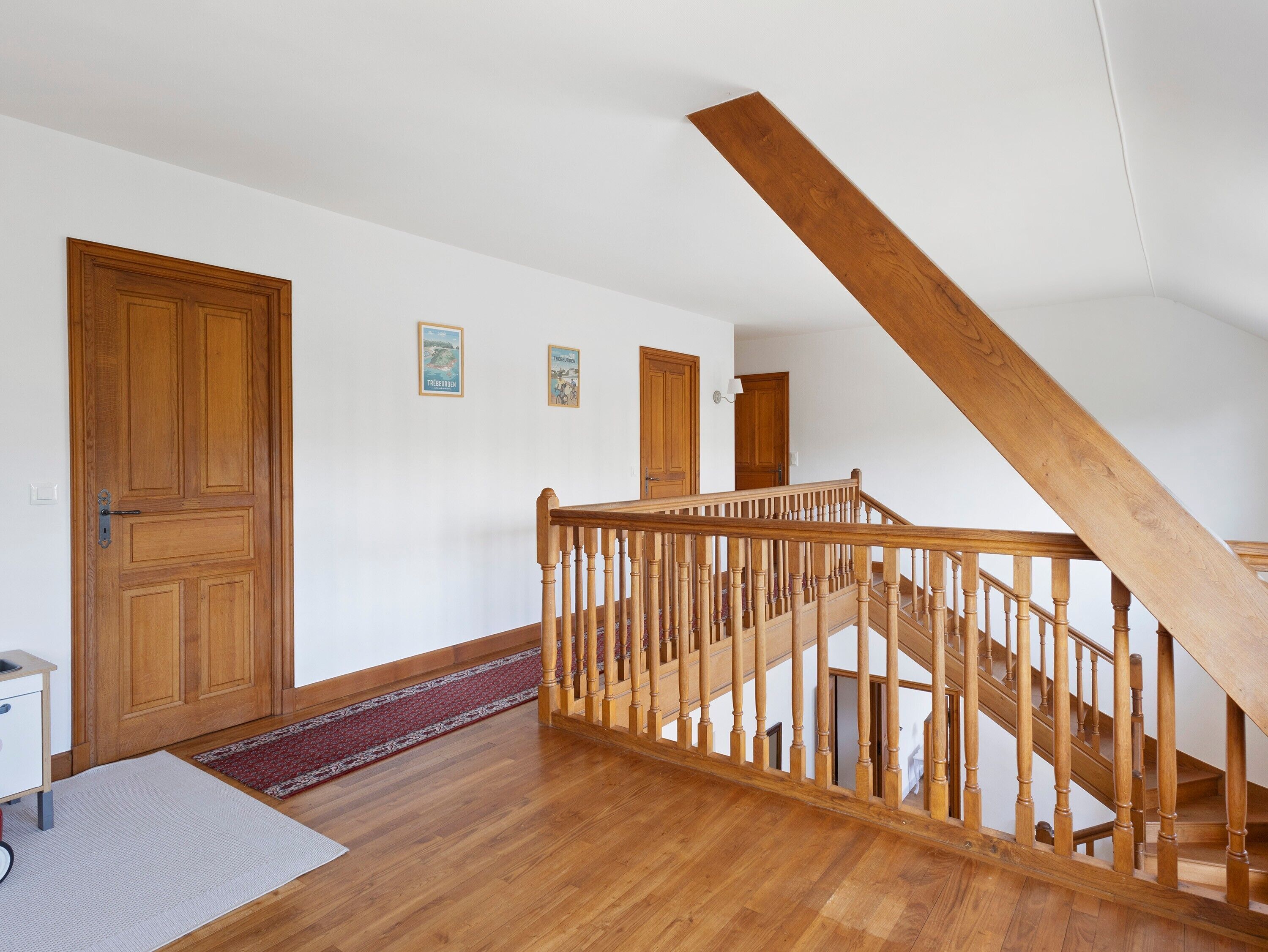 A wooden staircase with a handrail leading to an upper floor.