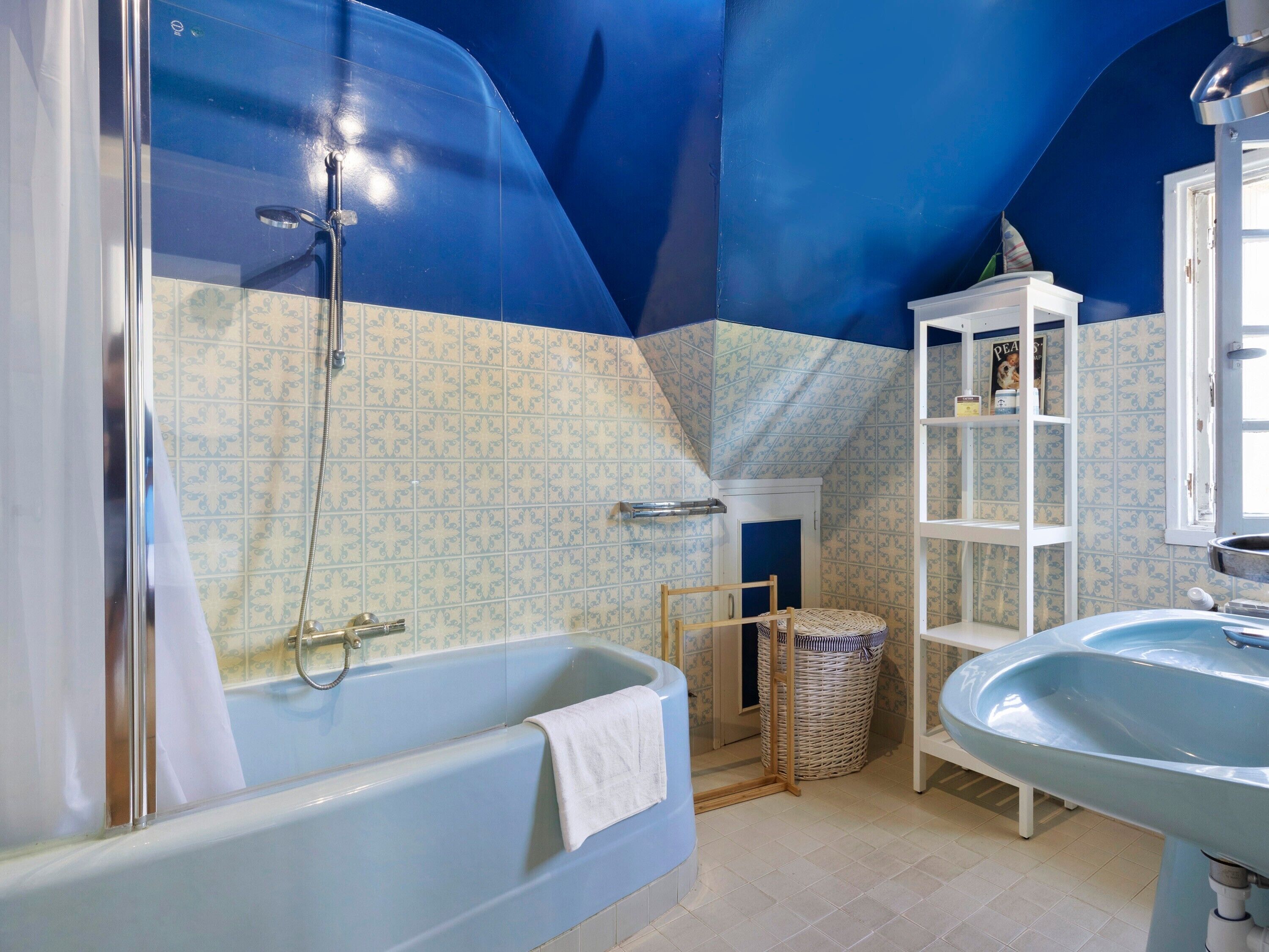 Ein Badezimmer mit einer Badewanne, einem Waschbecken, einer Dusche und einem Ablagefach mit Toilettenartikeln.