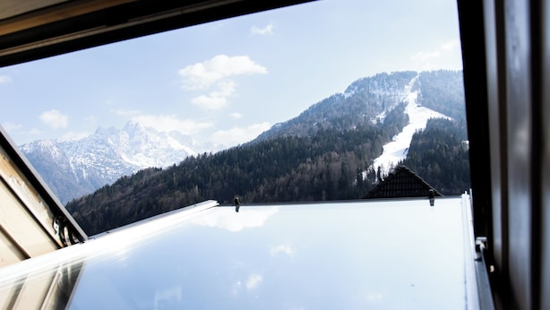 L'intérieur d'un véhicule, avec vue sur un paysage montagneux enneigé par une fenêtre ouverte.