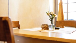 Une table en bois ornée d’un vase de fleurs, d’un bol décoratif et d’un téléphone intelligent.
