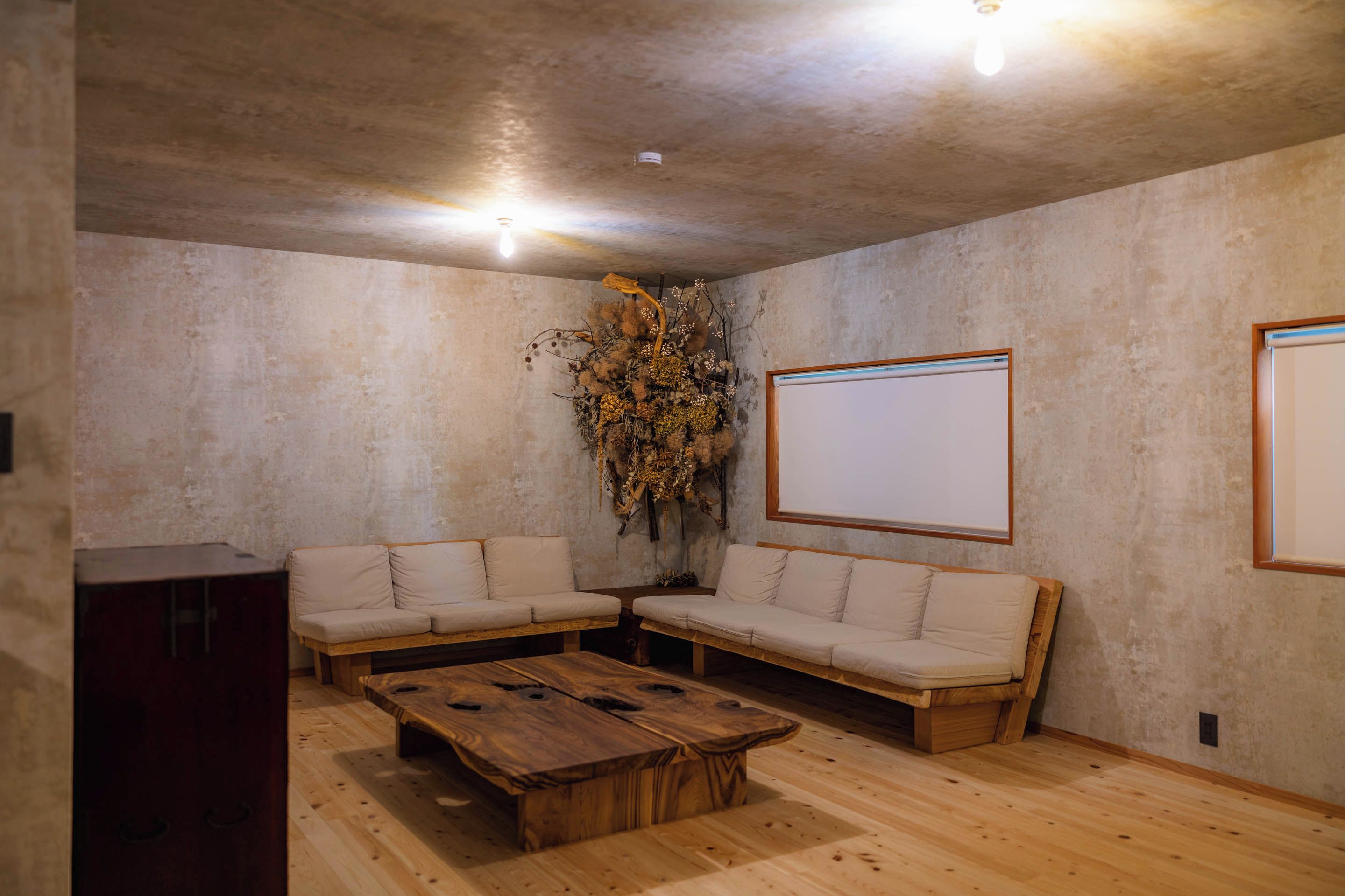 A room with a wooden coffee table, two sofas, a whiteboard, and a decorative plant.