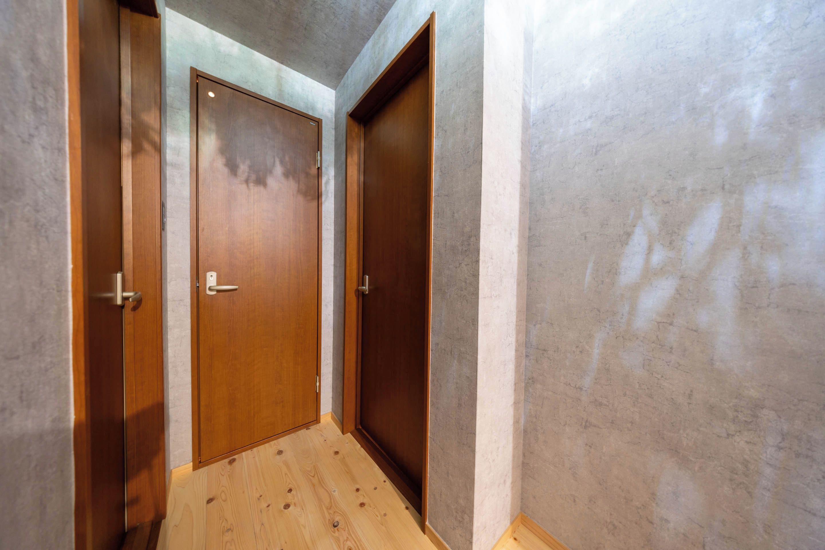 A hallway with wooden doors and a wooden floor.