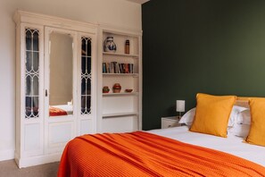 Una camera da letto con un letto, un armadio, un comodino e una libreria.