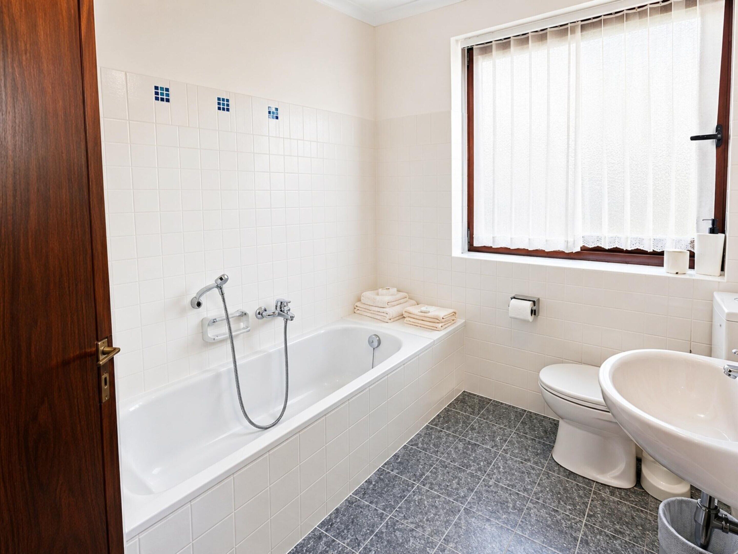 A bathroom with a bathtub, toilet, and sink.