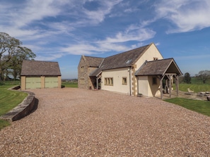 A gravel driveway leading to a building with a stone facade and a pitched roof. - Thimble Hill (Carlisle)