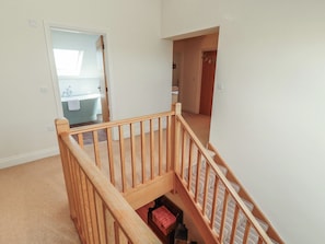 A staircase with wooden railings leading to a second-floor landing. - Thimble Hill (Carlisle)