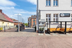 Ein Gebäude mit einem Schild für 'MORZE RESTAURACJA' und einem gepflasterten Weg mit Bänken.