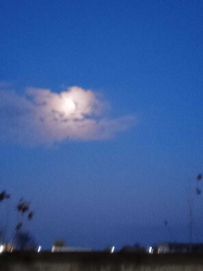 Ein klarer Nachthimmel mit Mond und vereinzelten Wolken.
