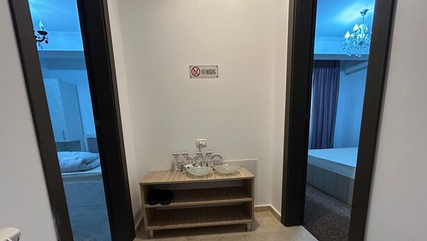 A bathroom with a 'No Smoking' sign, a vanity with a mirror, and a sink. - Vila Naty (Mamaia-Sat)