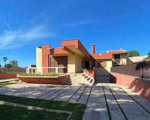 Una casa moderna amb teulada plana, un petit porxo davanter i un carrer d'accés pavimentat.
