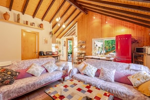Ein gemütliches Wohnzimmer mit zwei Sofas, einem Couchtisch und einem roten Kühlschrank.
