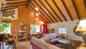 A cozy room with a wooden ceiling, a dining table, a sofa, and a red cabinet. - Rural Cabin 'La Casita de la Font del Bosc'. SPA. Charming Entire Rural House (La Font del Bosc)