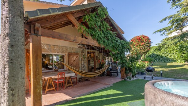 A wooden structure with a hammock, a hot tub, and a patio area with a table and chairs. - Rural Cabin 'La Casita de la Font del Bosc'. SPA. Charming Entire Rural House (La Font del Bosc)