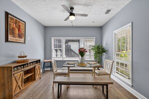 A dining area with a table set for four, a ceiling fan, and a window with blinds. - 2br Getaway Near I-75 World Cup 1 Bedroom Home (Jonesboro)