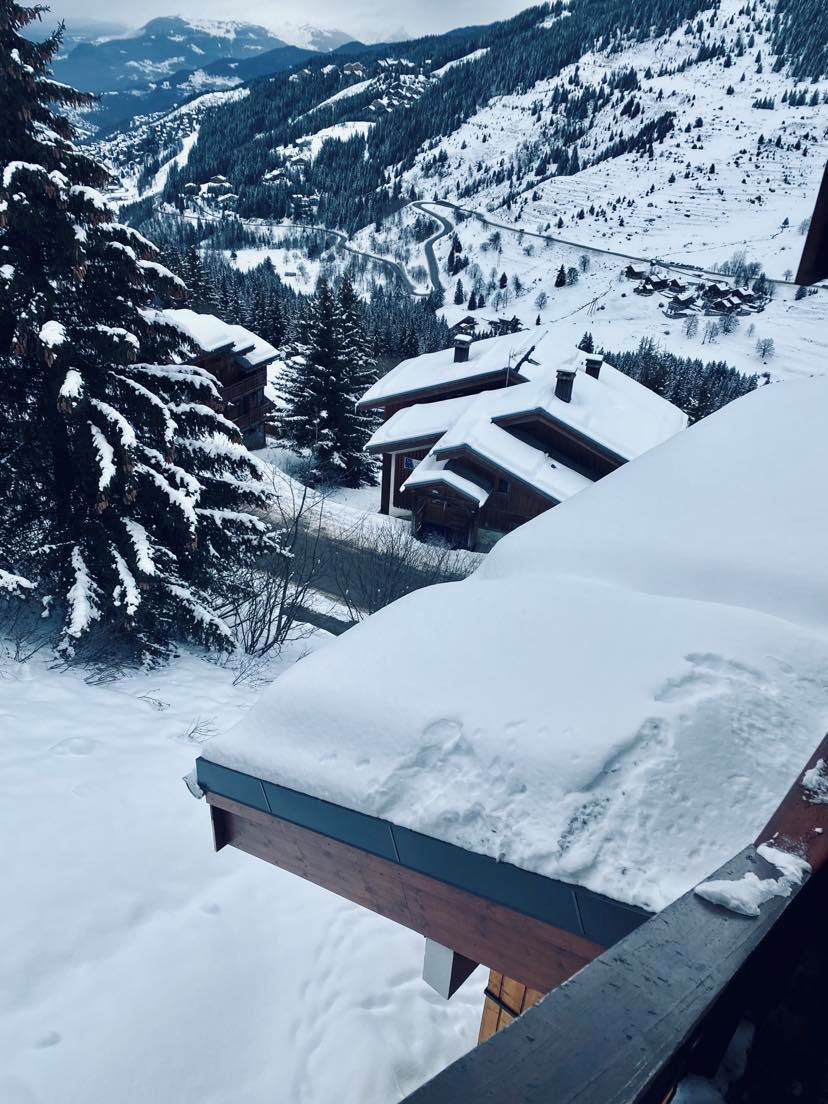 A snow-covered mountain landscape with a wooden cabin and a ski lift in the background.