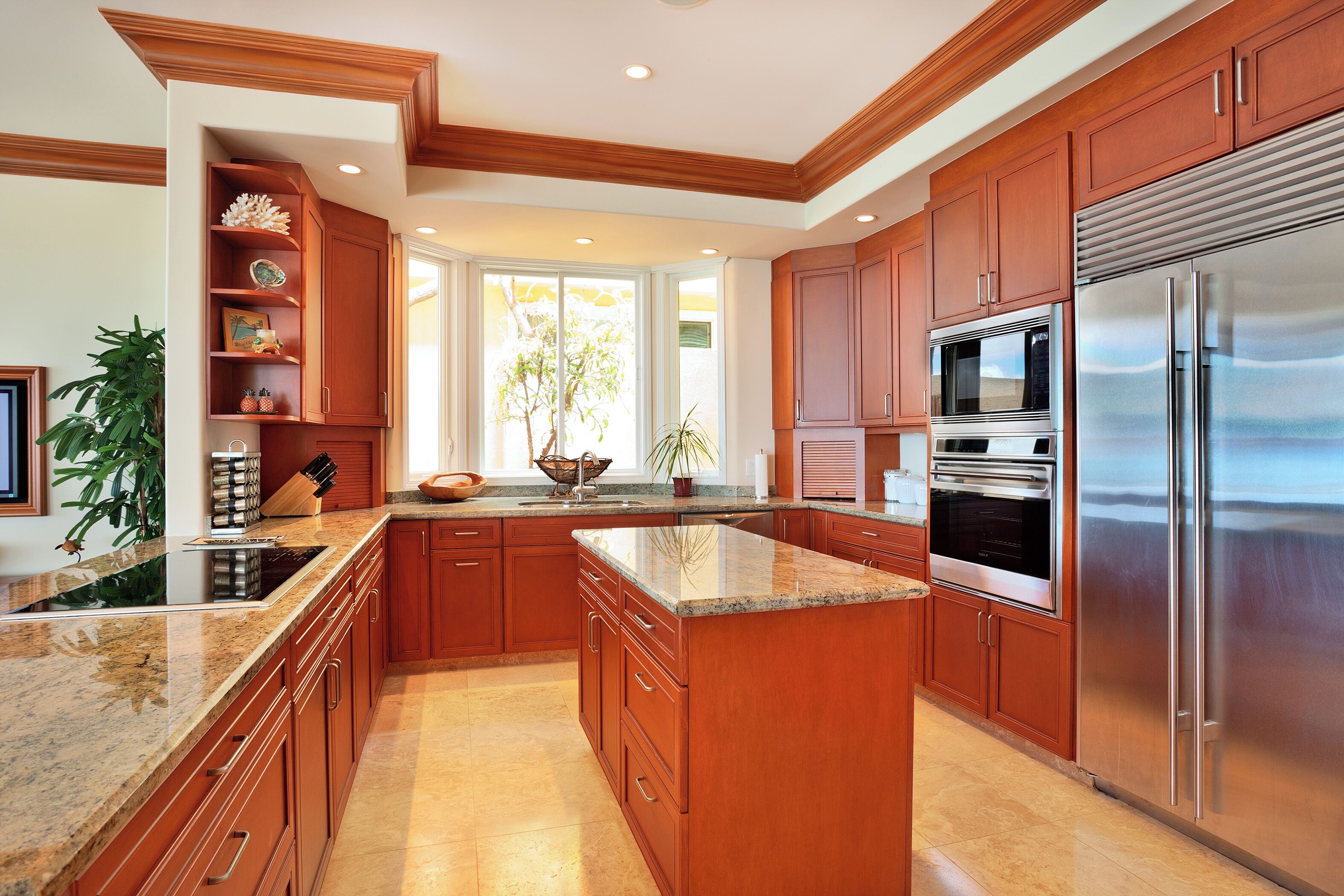 Una cocina con armarios de madera, electrodomésticos de acero inoxidable y encimera de granito.