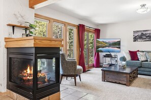 Ein Wohnzimmer mit Kamin, einer Couch, einem Couchtisch und einem Fernseher.