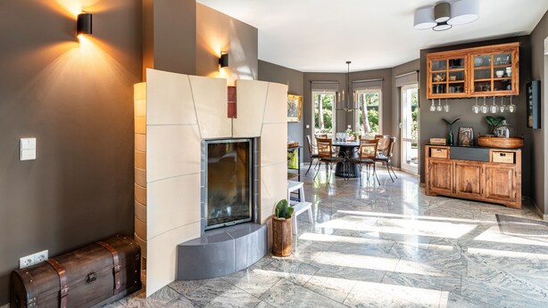 Un interior moderno con chimenea, comedor y armarios de madera.