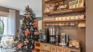 Un espace dédié au café, équipé d’une machine à café, de tasses et d’un présentoir de grains de café.