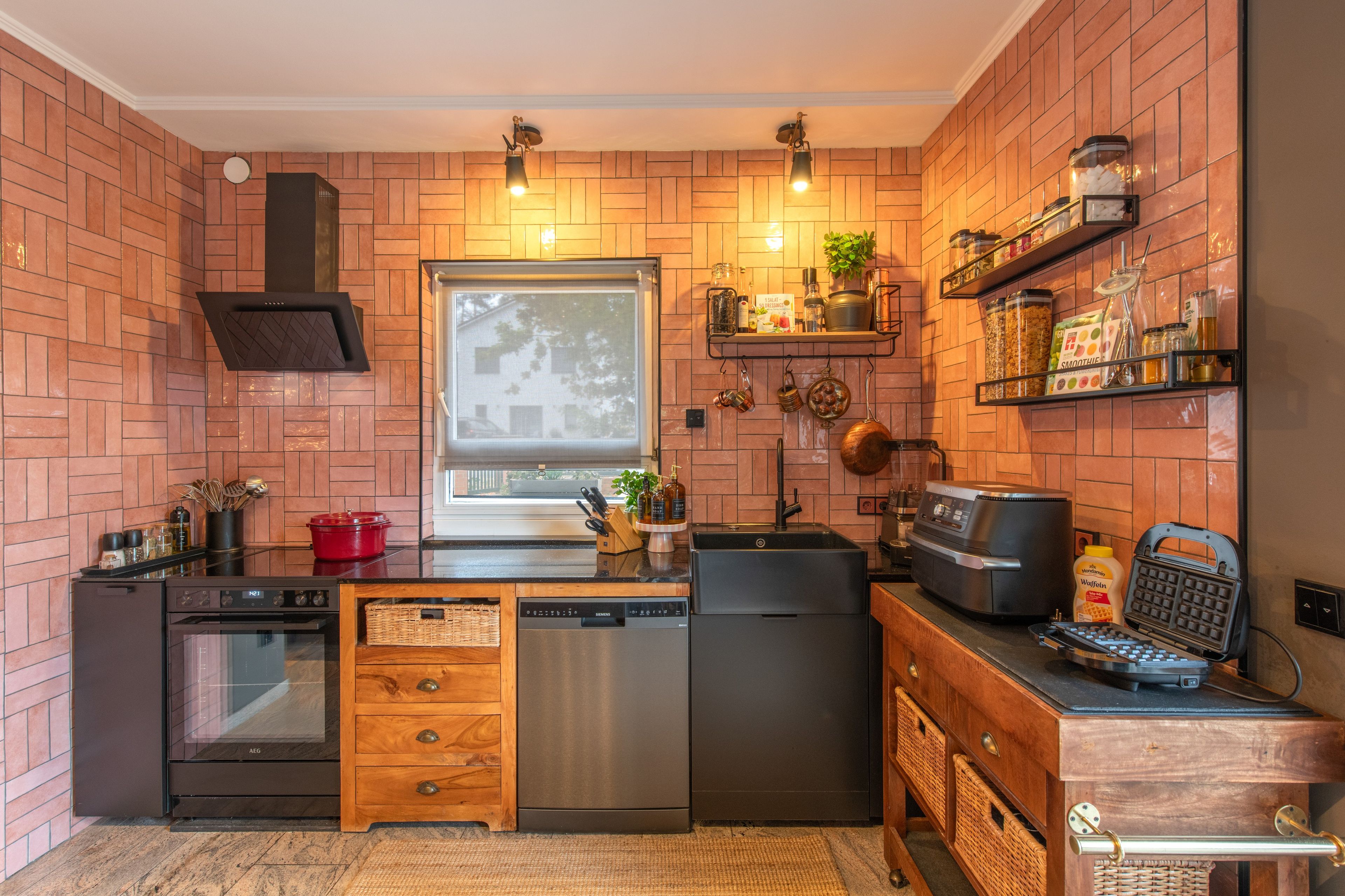 Una cocina compacta con horno integrado, lavavajillas, cocina y cafetera.