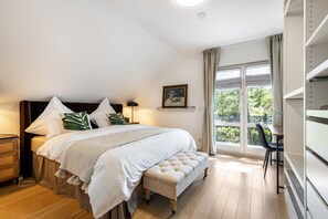 A bedroom with a bed, bedside tables, a bench, a desk, and a window with a view. - Luxury Lakeside Retreat Villa for 11 – Sandy Beach & 20 Mins to BER (Bestensee)