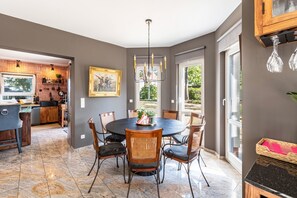 A dining area with a round table, six chairs, and a chandelier. - Luxury Lakeside Retreat Villa for 11 – Sandy Beach & 20 Mins to BER (Bestensee)