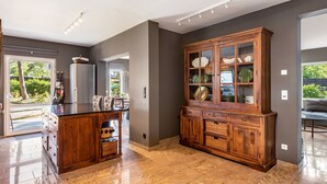 Cocina amplia con una isla central, armarios de madera y vistas al exterior.