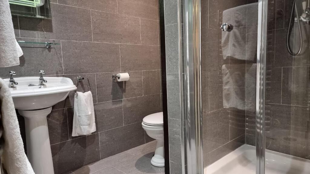 Ein Badezimmer mit Waschbecken, Toilette und einer Duschkabine.