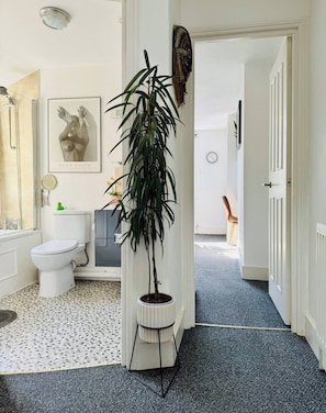 A bathroom with a toilet, sink, mirror, and a framed artwork on the wall. - Room-lovely Room In Brixton (London)