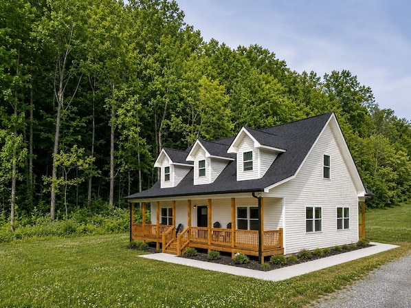 A two-story house with a porch, a garage, and a well-maintained lawn.
