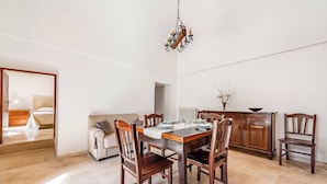 A dining area with a wooden table, chairs, and a chandelier. - Casolare Di Puglia With Private Pool (Noci)