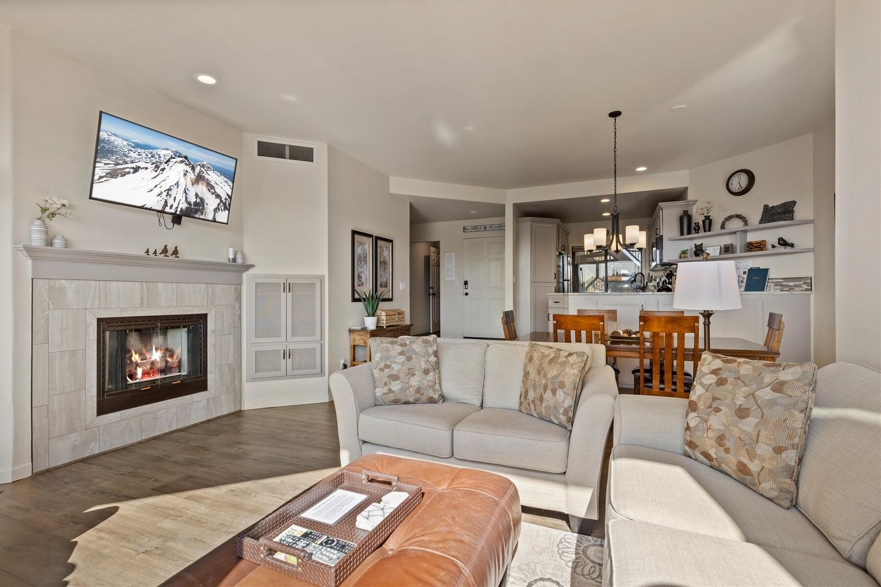 A living room with a fireplace, a sofa set, a coffee table, and a dining area with chairs and a table.
