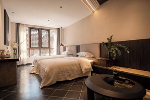 A modern hotel room with a large bed, a small desk, a round table, and a large window with a view. - Windy Wan Gang Wind Listening Art Hotel (Lijiang)