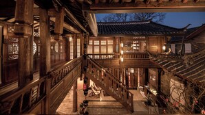A traditional wooden building with a staircase, wooden railings, and a tiled roof. - Windy Wan Gang Wind Listening Art Hotel (Lijiang)