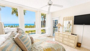 A bedroom with a bed, a dresser, a TV, and a view of the ocean. - 2/2 Gulf View condo at Beachplace on Longboat Key (Longboat Key)