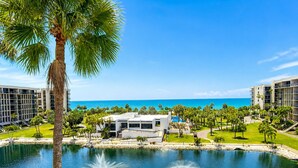 A resort with a pool, palm trees, and a view of the ocean. - 2/2 Gulf View condo at Beachplace on Longboat Key (Longboat Key)