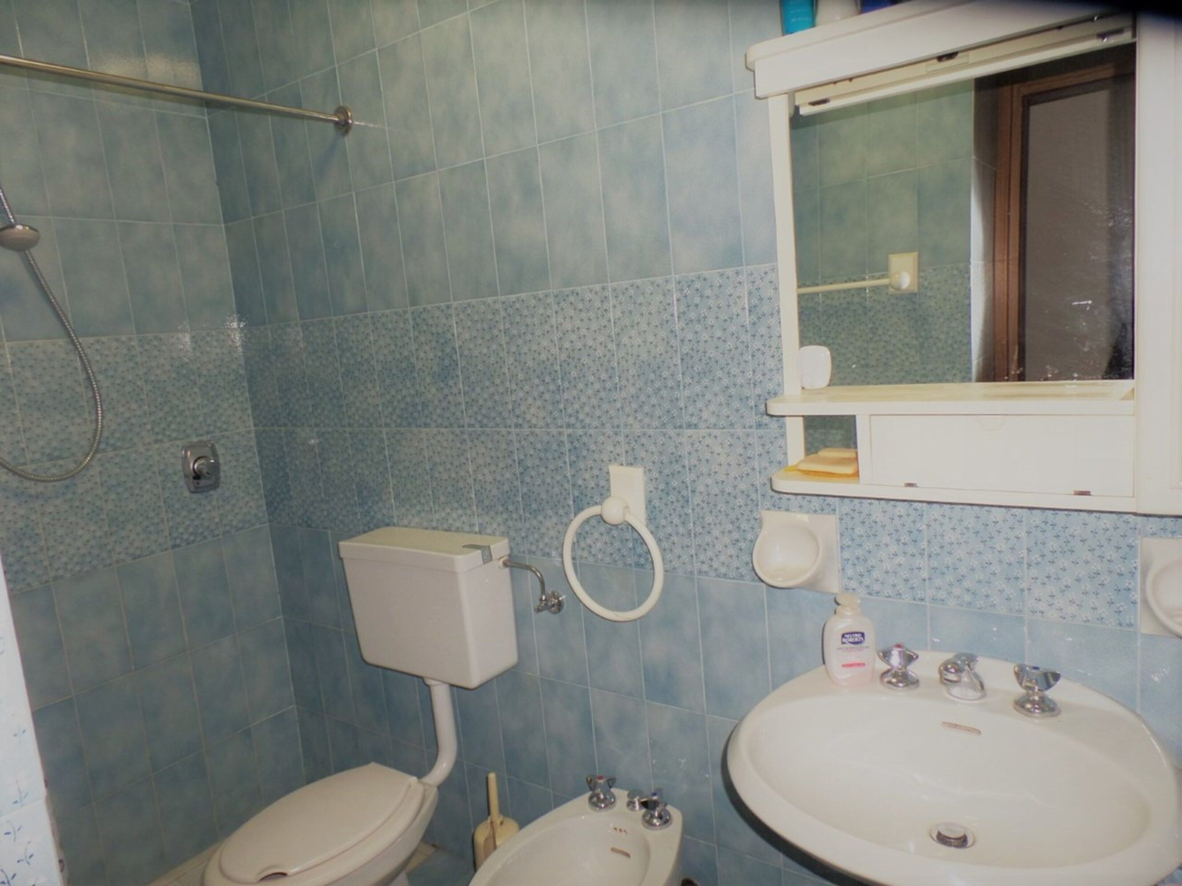 Un baño con inodoro, bidé y lavamanos.