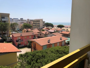 A residential area with buildings, a balcony, and a view of the sea. - Cozy sea View Studio With Terrace (San Michele al Tagliamento)