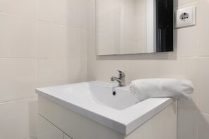 A bathroom with a white sink, a mirror, and a towel. - Lisbon Apartment – Excellent Central Location (Lisbon)