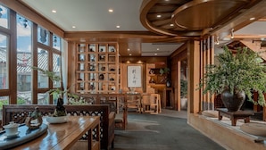 A traditional Japanese-style interior with wooden furniture, a tea set, and a calligraphy piece. - Cloudland Skystream View Designer Inn (Lijiang)