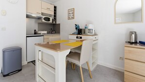 A compact kitchen with a microwave, coffee maker, and a small trash bin. - Air-conditioned studio for 2 people, near the shops (Grasse)