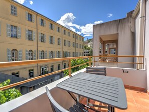 A balcony with a table and chairs, overlooking a cityscape with historic buildings. - Air-conditioned studio for 2 people, near the shops (Grasse)